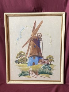 Stunning Vintage Windmill Hand Embroidered Silk Artwork Set In Glazed Frame. Circa- Vintage 1890 Composition- Hand Embroidered Silk Thread Artwork Condition - Lovely Vintage Original Beautifully Quaint And Detailed Composition Of A Large Windmill Set In Rich Flora & Forma Landscape. Rich Blue Rendered Windmill With Half Wooden Cladding Leading Up To Giant Turbines. Picturesque Details Of Wooden Door And Small Windows With Lovely Cottage Style Picket Fence & Planted Garden. Stunning Richly Coloured Composition Created Out Of Many Embroidery Stitches Which Include Straight / Back Stitch, French Knots And Running Stitches. Beautiful Example Of A Hand Embroidered Artwork Set In Glazed Wooden Frame. Dimensions In Inches Height 21.5” Width 17.5”
