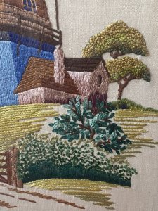 Stunning Vintage Windmill Hand Embroidered Silk Artwork Set In Glazed Frame. Circa- Vintage 1890 Composition- Hand Embroidered Silk Thread Artwork Condition - Lovely Vintage Original Beautifully Quaint And Detailed Composition Of A Large Windmill Set In Rich Flora & Forma Landscape. Rich Blue Rendered Windmill With Half Wooden Cladding Leading Up To Giant Turbines. Picturesque Details Of Wooden Door And Small Windows With Lovely Cottage Style Picket Fence & Planted Garden. Stunning Richly Coloured Composition Created Out Of Many Embroidery Stitches Which Include Straight / Back Stitch, French Knots And Running Stitches. Beautiful Example Of A Hand Embroidered Artwork Set In Glazed Wooden Frame. Dimensions In Inches Height 21.5” Width 17.5”