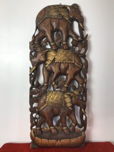 Large Hand Carved Plaque Of Balancing Trio Of Elephants In Hardwood & Gilt Work. Three Elephants Beautifully Carved With Delicate Flowers And Acanthus Vines Stand On Top Of One Another. Large Gilt Sunflower Motif As Base With Gilt Saddle Mats, Tusks, Ears And Anklets. Stunning Decorative Piece Dimensions In Inches Height 35” Width 14” Depth 1 1/4”