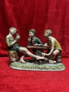 Capodimonte The Cheat’ Porcelain Sculpture Figurine Circa - 1970 Composition - Porcelain Listing Description Wonderful Iconic Capodimonte Figurine Depicting Three Boys Playing Cards, One Of The Boys Passes A Ace Of Diamonds Between His Toes To The Player Across Form Him, Hence Why The Showpiece Was Named 'The Cheat'. Original Pristine Condition. Dimensions In Cms Height 28cm X Width 19cm X Depth 14cm For Further Information Please Contact The Museum Curator On 07707 466588. Thank-you.