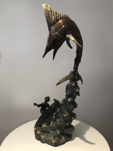Vintage 20th Century Quality Bronze Statue Merlin Fish & Fishing Boat Capsized With Gilded Rock Supporting The Elaborate Merlin Fish On The Top Showpiece Excellent Detail To The Sculpture Fisherman’s Face Impeccably Executed Wonderful Collectors Rare Statement Antique Look Bronze Statue Signed By Artist On Side Of Fishing Boat Weight Approx 15Kg Dimension In Inches Height 34” Width 15” Depth 11”