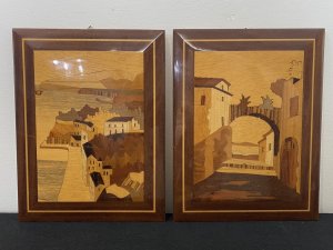 Pair Of Italian Landscapes Fruitwood Inlaid Sorrento Plaques. Circa - Vintage Composition- Fruitwood . Rosewood, Calamander Wood, Satinwood Inlays A Stunning Pair Of Hand Crafted Sorrento Parquetry Plaques Displaying Italian Landscapes. Hanging Hooks On The Back For Wall Display. First Plaque Italian Sea Scape With Mountainous Background And Headland. A Forest Area With Houses In The Foreground All Beautifully Hand Inlaid In Precious Fruit Woods. Rosewood Frame With Satinwood Boarder. Second Plaque Italian Village Scene With Ornamental Bridge And Walk Way Through Idyllic Houses. Stunning Details Of Arched Doorway, Bridge Foliage And Mountains In The Distance. Set In Rosewood Frame With Satinwood Border. Dimensions In Inches Height 9” Width 6 3/4”