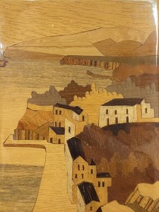 Pair Of Italian Landscapes Fruitwood Inlaid Sorrento Plaques. Circa - Vintage Composition- Fruitwood . Rosewood, Calamander Wood, Satinwood Inlays A Stunning Pair Of Hand Crafted Sorrento Parquetry Plaques Displaying Italian Landscapes. Hanging Hooks On The Back For Wall Display. First Plaque Italian Sea Scape With Mountainous Background And Headland. A Forest Area With Houses In The Foreground All Beautifully Hand Inlaid In Precious Fruit Woods. Rosewood Frame With Satinwood Boarder. Second Plaque Italian Village Scene With Ornamental Bridge And Walk Way Through Idyllic Houses. Stunning Details Of Arched Doorway, Bridge Foliage And Mountains In The Distance. Set In Rosewood Frame With Satinwood Border. Dimensions In Inches Height 9” Width 6 3/4”