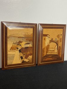 Pair Of Italian Landscapes Fruitwood Inlaid Sorrento Plaques. Circa - Vintage Composition- Fruitwood . Rosewood, Calamander Wood, Satinwood Inlays A Stunning Pair Of Hand Crafted Sorrento Parquetry Plaques Displaying Italian Landscapes. Hanging Hooks On The Back For Wall Display. First Plaque Italian Sea Scape With Mountainous Background And Headland. A Forest Area With Houses In The Foreground All Beautifully Hand Inlaid In Precious Fruit Woods. Rosewood Frame With Satinwood Boarder. Second Plaque Italian Village Scene With Ornamental Bridge And Walk Way Through Idyllic Houses. Stunning Details Of Arched Doorway, Bridge Foliage And Mountains In The Distance. Set In Rosewood Frame With Satinwood Border. Dimensions In Inches Height 9” Width 6 3/4”