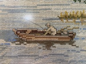 Hand Woven Lake Windermere Landscape Tapestry With Fisherman In Rowing Boat Circa - 20th Century Vintage Composition - Wool Work Intricate Woodwork Tapestry With Stunning Lake View Showing Fisherman Patiently Sitting In A Rowing Boat With His Fishing Rod Perched. The Lake Surrounded By Reeds, Lilly Pads And Water Daisies With Narrow Track To The Right With Detailed Trees And Jetty. Lovely Charming Subject With Stunning Perspective In A Array Of Vibrant Yellow, Green, And Blue Hues. Lake Scene Thought To Be At Lake Windermere. Framed / Unsigned Dimension In Inches Height 25.5" Width 31 1/4"