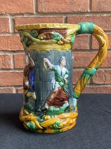 Large Minton Majolica Style Pitcher Jug With Dancing Maidens & Jesters Decoration. Circa - Vintage Reproduction Composition - Glazed Pottery/ Earthenware Beautiful Large Vibrant Glazed Pouring Jug In The Minton Majolica Style. This Design Is Typical Of Minton During The Late 19th Century. A Large Vine Like Structure Makes Up The Shaped Handle Which Entwines The Top & Bottom Edge Of The Jug With Sprays Of Grapes And Leaves. The Central Portion Of The Jug Has Large Relief Figures Of Maidens And Jesters Lavishly Posed Dancing. Very Decorative And Useable Piece. Condition- Used Vintage No Damage Lovely Condition. Dimensions In Cms Height 24.5cms Width 23cms Depth 11.5cms (top)