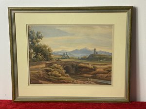 19C Aristocratic Romantic Castle Landscape Watercolour Painting By Lady Buetiau Hepburne. Circa - 1900 Composition - Watercolour On Velum Beautiful Watercolour Of A Romantic Landscape Composition Of Rolling Hills, Castles And Bridge Crossing In Italy With Detailed Flora And Forna. Impressive Coloration In Earth Hues Painted By The Fine Hand Of Aristocrat Lady Buetiau Hepburne Whilst On Vacation In Italy During The 1900. Signed On The Reverse And Set In Glazed Gilt Frame. Dimensions In Inches Height 13 1/4” Width 17 1/4”