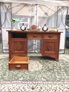 Famous Admiral Lord Nelson Style Admirality Office Desk In Solid Teak Wood. Admiralty Desk With 3 Pull Out Drawers And 2 Opening Cupboard Doors. Cupboards With Shelf Inside For Book, Map And Document Storage. Carved Column Pilasters On The Front With Ornate Plaque Carvings of Acanthus Leaves On Both Cupboard Doors And Ornate Carved Flora And Forna Handles On The Pull Out Drawers. Stands Upon Regency Brass Castor Feet. Exceptionally Solid Thick Teak Top Heavy And Stunning Quality Piece. Dimensions In Inches Height 33.5” Width 58.5” Depth 21.5 Kneehole Height From Floor 25” Kneehole Width 16”