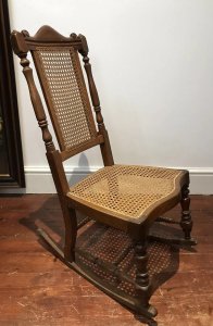 Aesthetic Movement Rare Cane Serpentine Front Spindle Back Rocking Chair Solid Wood Frame Made In Red Walnut Interesting Arched Back With Turned Stretchers And Engine Turned Legs Came Back And Seat Quality Chair With Sturdy Frame Showing Signs Of Wear Especially On The Rockers Conductive To Age And Usage Rare Piece And Original Antique Item Dimensions In Inches Height 35” Seat Height 14” Width 18” Depth 24”