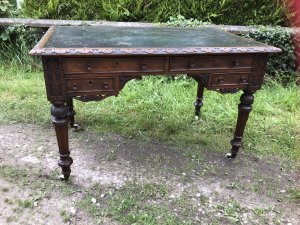 Fine Victorian Carved Writing Desk By Nelson London 1875 Cabinet Maker To Nobility Base Of Drawer Signed 3 Dovetail Drawers With Shaped And Carved Kneehole Original Green Well Weathered Leather Top Worn With Age And Usage Oak Desk Profoundly Carved All Around Stunning Carved Rose Handles Carved Acanthus Leaves On Turned Legs With Brass Wheel Feet Top Quality Hand Made Piece Provenance From Andross Castle Perthshire And Stored For Many Years In Surrey England Elegant Rare Desk Dimensions In Inches Height 31” Width 48” Depth 30”