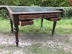 Fine Victorian Carved Writing Desk By Nelson London 1875 Cabinet Maker To Nobility Base Of Drawer Signed 3 Dovetail Drawers With Shaped And Carved Kneehole Original Green Well Weathered Leather Top Worn With Age And Usage Oak Desk Profoundly Carved All Around Stunning Carved Rose Handles Carved Acanthus Leaves On Turned Legs With Brass Wheel Feet Top Quality Hand Made Piece Provenance From Andross Castle Perthshire And Stored For Many Years In Surrey England Elegant Rare Desk Dimensions In Inches Height 31” Width 48” Depth 30”