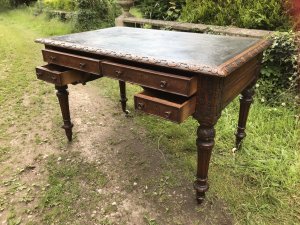 Fine Victorian Carved Writing Desk By Nelson London 1875 Cabinet Maker To Nobility Base Of Drawer Signed 3 Dovetail Drawers With Shaped And Carved Kneehole Original Green Well Weathered Leather Top Worn With Age And Usage Oak Desk Profoundly Carved All Around Stunning Carved Rose Handles Carved Acanthus Leaves On Turned Legs With Brass Wheel Feet Top Quality Hand Made Piece Provenance From Andross Castle Perthshire And Stored For Many Years In Surrey England Elegant Rare Desk Dimensions In Inches Height 31” Width 48” Depth 30”