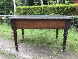 Fine Victorian Carved Writing Desk By Nelson London 1875 Cabinet Maker To Nobility Base Of Drawer Signed 3 Dovetail Drawers With Shaped And Carved Kneehole Original Green Well Weathered Leather Top Worn With Age And Usage Oak Desk Profoundly Carved All Around Stunning Carved Rose Handles Carved Acanthus Leaves On Turned Legs With Brass Wheel Feet Top Quality Hand Made Piece Provenance From Andross Castle Perthshire And Stored For Many Years In Surrey England Elegant Rare Desk Dimensions In Inches Height 31” Width 48” Depth 30”