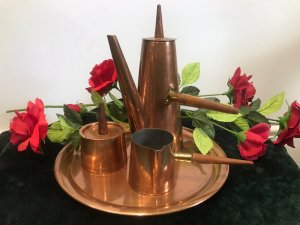 Vintage Arts And Crafts Conical Shaped Copper 4 Pcs Coffee Set By ARGY Europe 4 Piece Set Includes Conical Shaped Coffee Pot, Cream Jug And Lidded Sugar Basin With Teak Handles Sitting On Copper Circular Tray Unique Stylish Design Composition - Copper Outer With Tin Lining Condition- Used Good Circa - 1930’s Signs Of Wear Small Dents And Scratches Dow To Age And Usage Dimensions In Inches Tray Diameter 10.5” Coffee pot height 9.5” Width 3.5” Sugar Basin Height 4” Width 2 3/4” Cream Jug Height 2.5” Width 2.5”