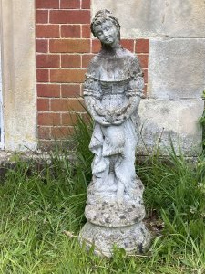 Andromeda Grecian Goddess Holding Turtle Dove Vintage Garden Sculpture. Circa - Vintage Composition- Reconstituted Stone Stunning Grecian Beauty Dressed In Elaborate Off The Shoulder Tiered Gown Holding Turtle Dove. Detailed Gown With Frills, Ribbons And Bows. Goddess With Delicate Facial Features Standing Upon Circular Plinth Base Decorated With Roses. Provenance Purchased From Port Elliot, Lisgaurd Cornwall. Dimensions In Cms Height 83cm Width 27cm Depth 27cm