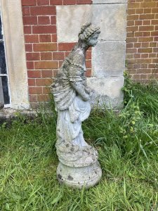 Andromeda Grecian Goddess Holding Turtle Dove Vintage Garden Sculpture. Circa - Vintage Composition- Reconstituted Stone Stunning Grecian Beauty Dressed In Elaborate Off The Shoulder Tiered Gown Holding Turtle Dove. Detailed Gown With Frills, Ribbons And Bows. Goddess With Delicate Facial Features Standing Upon Circular Plinth Base Decorated With Roses. Provenance Purchased From Port Elliot, Lisgaurd Cornwall. Dimensions In Cms Height 83cm Width 27cm Depth 27cm