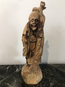 Two Oriental Fruitwood Carvings One Female With Fine Carved Robe Details Holding Flowers One Large Male Carving With Unusual Long Carved Hair And Flowing Robe Origin Unknown Presumed To Be Chinese Collectors Items Dimensions In Inches Male Height 15” Width 4” Female Height 12” Width 3.5”
