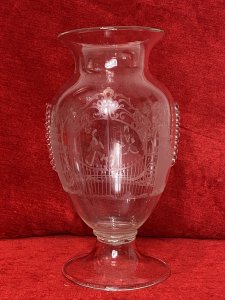 French Antique 19th Century Palace Of Versailles Etched Glass Decorative Vase. Circa - 1850 Origin - France Fine Quality Beautifully Detailed And Hand Crafted Etched Glass Vase With Overlaid Glass Ornamentation. Bouquet Shaped Vase With Round Glass Plinth Base Pediment. The Front Depicting The Palace Of Versailles Grand Entrance Gates With Column Pillars Adorned With Putti. On The Reverse Male And Female Believed To Be Marie Antoinette & Louis XVI Posed Figures In Traditional 18th Century Clothing In Stunning Tree Veranda Scene. Hand Blown Pontil Mark On The Base. Finely Engraved But Craftsman Unknown No Makers Mark. Dimensions In Inches Height 9 1/2” Width 5 1/4” Neck Diam 4.5” Base Diam 4.5”