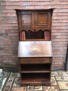 Fine Red Walnut Arts And Crafts Secretaire Bookcase Shaped Top Pediment With Double Doors For Book Storage Drop Down Front With Pull Out Supports Displaying Stunning Satinwood And Pewter Inlays Of Musical Instruments And Foliage Shelves Under Pull Out Drawer Red Walnut Cabinet With With Oak Lined Drawer Delightful Item In Beautiful Condition With Original Key Dimensions In Inches Height 65” Width 28” Depth 15”