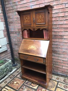 Fine Red Walnut Arts And Crafts Secretaire Bookcase Shaped Top Pediment With Double Doors For Book Storage Drop Down Front With Pull Out Supports Displaying Stunning Satinwood And Pewter Inlays Of Musical Instruments And Foliage Shelves Under Pull Out Drawer Red Walnut Cabinet With With Oak Lined Drawer Delightful Item In Beautiful Condition With Original Key Dimensions In Inches Height 65” Width 28” Depth 15”