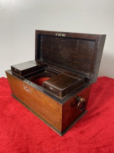 William IIII Rosewood Sarcophagus Shaped Tea Caddy With Mother Of Pearl Inlay Beautiful Solid Rosewood Tea Caddy Chest With Egg And Dart Gadrooned Top Edge With Mother Of Pearl Inlay Floral Motifs On The Top Lid ( Monogramed R.H.B) And Around Lock. Each Side Bears Drop Ring Handles. (One Missing) Inside The Chest There Are Two Hinged Top Compartments For Tea And A Circular Slot For Mixing Bowl Or Drinking Flask. Stunning Rich Patina Antique Tea Chest. Dimensions In Inches Height 8” Width 13” Depth 6”