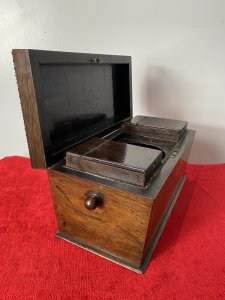 William IIII Rosewood Sarcophagus Shaped Tea Caddy With Mother Of Pearl Inlay Beautiful Solid Rosewood Tea Caddy Chest With Egg And Dart Gadrooned Top Edge With Mother Of Pearl Inlay Floral Motifs On The Top Lid ( Monogramed R.H.B) And Around Lock. Each Side Bears Drop Ring Handles. (One Missing) Inside The Chest There Are Two Hinged Top Compartments For Tea And A Circular Slot For Mixing Bowl Or Drinking Flask. Stunning Rich Patina Antique Tea Chest. Dimensions In Inches Height 8” Width 13” Depth 6”