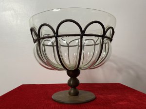 Daum And Majorelle Style Art Deco Blown Glass And Wrought Iron Centrepiece Bowl Circa - 1910 Origin - France Composition - Hand Blown Glass And Wrought Iron Listing Description Large Early French Art Deco Iridescent Hand Blown Glass Bowl, Set Into Decorative Wrought Iron Exoskeleton Shell. The Shell Is Made Up Of Twelve Segments With Bulbous Glass Protruding Apertures And Ornamental Scalloped Frill Along The Under Edge Of The Glass Bowl. Set Upon Cylindrical Tiered Base With Circular Platform Plinth. *The Glass Interior Cannot Be Removed From The Wrought Iron Shell.* This Bowl Is Thought To Be An Early Example Of Daum And Majorelle Works Which Where Exhibited At The World Fair In Paris 1900. Examples Of The Same Strap Work As In This Item Have Been Shown In Their Later Works. This Bowl Is Unsigned Although Some of The Earlier Works Were Unsigned Or Marked On The Lower Edges And Then Covered With Metal Banding. Stunning Collectors Item For Decorative Centrepiece Display. Condition The Bowl Is Completely Original And Showing Signs Of Age To The Metal Frame Work Conducive To Age And Usage . Internal Glass Bowl In Pristine Condition. Dimensions In Cms Height 26.5cm Bowl Opening Width 31cm Base Diam 16cm