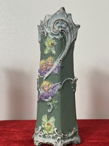 Pair Of Elaborate French Parian Ware 'Trio Of Winged Putti' Posey Vases Circa - Composition - Bisque Porcelain Colour - Green Listing Description Pair Of Hexagonal Cylinder Vases In Hard Paste Porcelain With Elaborated Decoration Of Three Winged Cherubs With Only Faces And Wings Visible. Putti With Vibrant Blonde Curled Hair, Tonal Skin With Delicate Facial Features And Purple Wings. A Detailed Floral Relief Pattern With Thistles & Hand Painted Gilt Work On Around Neck And Base Of Vases. Numbered On Bases Condition - Antique Used Minor Chip On The Neck Of One Vase Conducive To Age. Please See Images. For Further Images Or Assistance Please Call 07376618513 Dimensions in Inches Height Width Depth