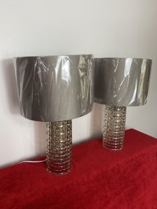 Pair Modern Art Contemporary Geometric Glass Lamps With Shades. Circa - Modern Reproduction Composition - Glass Condition - Used Pristine Matching Pair Of Modernistic Designer Glass Table Top Lamps, Both Cylindrical Bases In A Geometric Pattern With Holographic Finish In Champagne Colour. Singular Bulb Fixtures With British Corded Plug With On/Off Switch. Complete With Beige Gold Shade. Unused/ Unboxed Dimensions In Inches Height With Shades 19" Base Height Including Bulb Mount 15.5" Base Diameter 4 1/4"