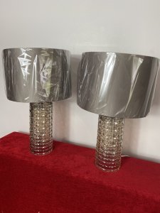 Pair Modern Art Contemporary Geometric Glass Lamps With Shades. Circa - Modern Reproduction Composition - Glass Condition - Used Pristine Matching Pair Of Modernistic Designer Glass Table Top Lamps, Both Cylindrical Bases In A Geometric Pattern With Holographic Finish In Champagne Colour. Singular Bulb Fixtures With British Corded Plug With On/Off Switch. Complete With Beige Gold Shade. Unused/ Unboxed Dimensions In Inches Height With Shades 19" Base Height Including Bulb Mount 15.5" Base Diameter 4 1/4"