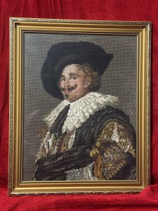 The Laughing Cavalier Wool-work Tapestry After Frans Hals 1624 Circa - Vintage Composition - Wool Weave/ Glazed Gilt Frame Listing Description Finely Hand Woven Wool Work Tapestry Composition Of Known Portrait Titled 'The Laughing Cavelier' By Dutch Golden Age Painter Frans Hals Dated 1624. The Original Painted Portrait Is Housed At The Prestigious Wallace Collection In London. The Cavalier In Deep Earthy Toned Colour Palette With Vivid Patterned Tunic, Large White Neck Ruff And Typical Wide Brimmed Hat. Facial Features In Fine Details. Charming Piece Set In Glazed Ornate Gilt Frame. Dimensions In Inches Height 19.5" x width 16" For Further Information Please Call The Museum Curator On 07707 488566 Thankyou.