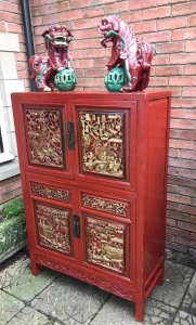 Rare Imperial Red Lacquer & Gilt Marriage Cabinet With Hand Carved Panels Hand Carved Gilt Panels On The Front Doors Depicting Battle Scenes With Extraordinary Horses, Warriors, Fruit & Foliage. 4 Opening Doors With Shaped Metal Handels With Two Drawers And Shelving Inside. Craftsman Seal Signed On The Front Panel With Fielded Side Panels Stands Upon 4 Sturdy Legs Museum Piece Exceptional Quality Cabinet Composition- Carved Fruitwood With Red Lacquer And Gilt Work Overall Condition- Very Good Provenance Part Of Oriental Private Collection At The Lord Hill Museum Please Note This Is A Antique Piece And May Have Blemishes And Signs Of Use And Wear Due To Age Dimensions In Inches Height 55” Width 37” Depth 15.5”