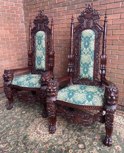 Fine Reproduction Pair Of Colonial Throne Seats With Lion Claw Feet. Circa - Vintage Reproduction Composition- Hardwood Exceptional Pair Of Profusely Carved High Back Throne Chairs. Towering High Backs With Central Coat Of Arms Plaque With Double Pinnacles Leading Down Into Lion Head Armrests. The Decorative Back Rests Hand Carved With Scrolled Acanthus Leaves & Entwined Coats Of Arms With Central Cushioned Panel Finished With Brass Stud Design. A Lovely Wide Seat Upholstered With Rich Green/Gold Silk Decorated With Bouquets Of Flowers, Swags And Tassels. Standing Upon Elaborate Lion Claw Feet With Rose Motifs. Stunning Hand Carved Craftsman Made Hardwood Chairs Finished In French Polished Patina. Original Condition A Museum Quality Pair. Fabulous Pair For Prestigious Collector/ Interior Designer /Film Production Prop. Would Look Amazing Next To Large Fireplace Or In Elaborate Entrance Hall / Lounge Area. Provenance Purchased From Prestigious Castle In The Scottish Highlands. Dimensions In Cms Back Height 185cm Width 90cm Seat Width 52cm Front To Back Depth 73cm