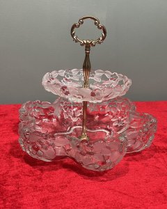 Mid Century Mikasa Walther Crystal Two Tier Cascading Fruit Bowl Circa - 1980 Composition - Glass Listing Description Stunning Top Tiered Fruit Bowl By Mikasa Walther. Each Bowls Shape Is Composition Of Six Circular Lobes Creating Its Scalloped Floral Motif Shape. Top Tier Is Diminishing in Size, With Larger Bowl Base. Stunning Floral Edelweiss Frosted Floral Pattered Cut Crystal Glass With Central Pinnacle With Floral Crescent Handle. Condition - Excellent No Damage - Minor Laquer Tarnishing To Brass Central Stand. Dimensions In Inches Height 9.5" X Width 10.5" (Largest Bowl) For Further Information Please Message or Call 07707 488 566 Thank-you