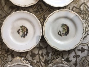 Rare 8Pc Collection Of Limoges France Hand Painted Dessert Comport Plates. Circa 1875 Stunning 8Pc Collection Of Porcelain Comport Plates With Scalloped Gilt Edges With Fine Painted Panels Of Various Landscapes In France Depicting Castles, Cathedrals, River Bridges And Fisherman. Two Plates With Shell Carry Handles For Carrying Desserts And BonBons To The Table Would Be A Fabulous On The Wall Display But Are Perfectly Good To Use Also. Unsigned Please Note There Is A Slight Crack In One Plate Due To Age And Usage. These Are Antique Plates And Have Signs Of Wear Dimensions In Inches Larger Handle Plate - Width 11.5” Diameter 10” 2nd Plate Width With Handle - Width 10.5 Diameter 9.5” 6 Plates Uniform Size Diameter - 9”