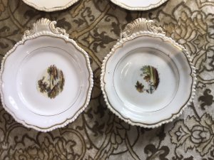 Rare 8Pc Collection Of Limoges France Hand Painted Dessert Comport Plates. Circa 1875 Stunning 8Pc Collection Of Porcelain Comport Plates With Scalloped Gilt Edges With Fine Painted Panels Of Various Landscapes In France Depicting Castles, Cathedrals, River Bridges And Fisherman. Two Plates With Shell Carry Handles For Carrying Desserts And BonBons To The Table Would Be A Fabulous On The Wall Display But Are Perfectly Good To Use Also. Unsigned Please Note There Is A Slight Crack In One Plate Due To Age And Usage. These Are Antique Plates And Have Signs Of Wear Dimensions In Inches Larger Handle Plate - Width 11.5” Diameter 10” 2nd Plate Width With Handle - Width 10.5 Diameter 9.5” 6 Plates Uniform Size Diameter - 9”