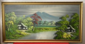 20th Century Indonesian Native Volcanic Settlement Landscape Oil Painting. Medium - Oil On Canvas Circa - 20th Century Striking Background Mountain View Looms With Meandering River With Intricately Painted Native Pagoda Homes In The Foreground. Surrounded By Exotic Foliage Of Palms, Banana Plants And Other Native Specimens. Stunning Perspective With Vibrant Hues Of Green With Blue Volcanic Mountain & Shadows And Accents Of Rich Red. Set In Gilt Wood Frame Unsigned Dimensions In Inches Height 26.5” Width 31.5”