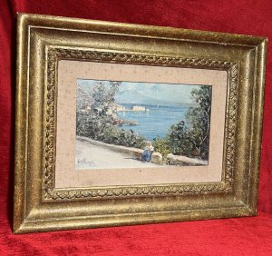 British Fine Art Oil Painting Of Portuguese Coastal View Attributed To Edward Seago Circa - 1950 Composition - Oil On Canvas Brief Artist History Edward Brian Seago March 31st 1910 - January 19th 1974 English Watercolour And Oil Artist Known For Beachscapes And Streetscenes. Edward Seago Briefly Studied With The Painter Sir Alfred Munnings, But Was Mostly Self Taught. Seago Worked In The Late Impressionistic Style Reminiscent Of John Singer Sargent. Seago's Work Is Characterised By Its Very Carefully Observed Colour Modulation And Grounded Sense Of Realism. Edward Seago's Works Are Notably Collected By British Royalty Including Queen Elizabeth, The Queen Mother And Prince Phillip, With Many Of His Finest Artwork Displayed On The Walls Balmoral. Today Seago's Artworks Are Found in Collections Of The Fine Art Gallery San Fransisco, The Royal Collection In London As Well As The National Portrait Gallery London. Listing Description Finely Detailed Impressionist Artwork Attributed To Edward Brian Seago Of Portuguese Coastal View With Forefront Depicting Female Sitting Upon A Wall On Roadside, Fabulous Sea View Behind With Surrounding Native Foliage, Central Coastal Town Bay And Sea Line Flowing Into The Distance. Vibrant Colour Palette Showing Landscape In Vivid Sunshine With Clear Skies And Rich Blue Seas. Quality Artwork Signed E SEAGO Set With Canvas Boarder In Original Gilt Frame. Condition - Excellent Showing Signs Of Damp To Canvas Boarder. Paintwork In Good Order. Dimensions In Inches Frame Height 14.5" X Width 18.5" Painting Height 6.5" X Width 10.5"