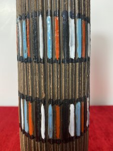 Designer Italian Mid Century Modern Textural Leaning Tower Of Pisa Inspired Vase Circa - 1950's Composition - Earthenware Tall Mid Century Earthenware Cylindrical Leaning Vase With Inspiration From The Leaning Tower Of Pisa. The Hand Sculpted Body Of the Vase Is Made Of Parallel Textural Lines Pattern And Decorated With Rings Of Gloss Coloured Paint Strokes In Blue, White, Red Which Mimic The Windows Of The Leaning Tower Of Pisa. Lovely Useful Collectors Piece In Vivid Colour. Signed On Base. Dimension In Inches Height 11 3/4" Base Diameter 3" Mouth Diameter 1 3/4"
