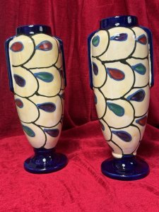 Pair Of Art Deco Ditmar Urbach Czechoslovakian Art Pottery Vases Listing Description Exceptional Sought After Period Art Deco Ditmar Urbach Art Pottery Vases. A Czechoslovakian Art Pottery Company Best Known For Decorative Pieces In The Art Deco Style, Their Primary Production Period During 1920-1930, With A Focus On Hand Painted, Distinctive Forms And Unique Sculptural Pieces. These Art Pottery Pieces Are now Highly Collectable Amongst Collectors Of The Art Deco Period. This Pair Of Tall Vases Showcase A Geometric Style Pattern Of Stylised Teardrop Shaped Motifs, In Plum, Blue And Green With Cream Body And Dark Blue Mouth And Base. Both Have Matching Markings On The Base. Stunning Original Condition. Kindly Call The Museum Curator For More Information On 07707 488566 Thank-you. Dimensions In Cms. Height 29cm x Width 13cm x Mouth 6.5cm x Base 9cm