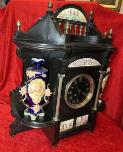 Rare Historic French Aristocracy Aesthetic Movement Timepiece Circa - 19th Century 1880 Composition - Slate/ Brass/ Porcelain Listing Description Impeccable Museum Quality French Aesthetic Movement Timepiece. A Wonderfully Decorative Architectural Clock In A Medieval Temple Shape. The Top Section Has A Stepped Platform For Display Of Decorative Curiosities, With Elaborate Six Pillared Brass Finial Mounts. The Central Portion Showcases A Half Moon Porcelain Plaque With Painted Aristoractic Figures In Clothing Of The Period Which Sits Directly Above A Brass Banister Frieze. Underneath The Platform A Hand Painted Enamel Artwork With The Original French Family Coat Of Arms With Acanthus Leaf And Mistletoe Sprays. A Circular Black Enamel Clock Face With Gilt Roman Numeral Dial Encased Either Side By Ornate Brass Corinthian Pillars And Surrounding Corner Shelve Mounts (Also For Decorative Display). A Elegant Base Section With Central Plaques Of French Castle And Landscape Scenes Standing Upon Six Bun Feet. Integral 8 Day Movement Complete With Original Winding Key And Pendulum. Condition - Very Good Clock Case Showing Minor Signs Of Wear. Scuffs, Scratches & Minor Chips Visible Conducive To Age And Usage. Movement In Good Working Order. Dimensions In Inches Height 21.5" Width 19" Depth6"