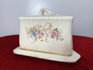 Victorian Royal Dolton Triangular Cheese Wheel Comport Dish & Cover. Circa -1870 Triangular Wedge Shaped Large Cheese Dish Comprising Of Lift Up Lid With Ornate Handle. Decorated With Sprays Of Meadow Flowers In Pastel Pink, Blue And Yellow Hues. Wedge Shaped Cheese Tray Showing Signs Of Age With Marks In Glaze From Usage. Holes In Lid To Allow Cheese To Air. Stunning Conversation Piece And A Beautiful Example Of Antique Victorian Royal Dolton. Clearly Marked On Bass And Inside Lid. Condition- Antique Used No Damage Cracks Visible In Glaze Only Due To Age And Wear Marks On Cheese Tray Base Please See Images. Dimensions In Inches Height 8” Width 11” Length 9.5”