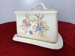 Victorian Royal Dolton Triangular Cheese Wheel Comport Dish & Cover. Circa -1870 Triangular Wedge Shaped Large Cheese Dish Comprising Of Lift Up Lid With Ornate Handle. Decorated With Sprays Of Meadow Flowers In Pastel Pink, Blue And Yellow Hues. Wedge Shaped Cheese Tray Showing Signs Of Age With Marks In Glaze From Usage. Holes In Lid To Allow Cheese To Air. Stunning Conversation Piece And A Beautiful Example Of Antique Victorian Royal Dolton. Clearly Marked On Bass And Inside Lid. Condition- Antique Used No Damage Cracks Visible In Glaze Only Due To Age And Wear Marks On Cheese Tray Base Please See Images. Dimensions In Inches Height 8” Width 11” Length 9.5”