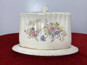 Victorian Royal Dolton Triangular Cheese Wheel Comport Dish & Cover. Circa -1870 Triangular Wedge Shaped Large Cheese Dish Comprising Of Lift Up Lid With Ornate Handle. Decorated With Sprays Of Meadow Flowers In Pastel Pink, Blue And Yellow Hues. Wedge Shaped Cheese Tray Showing Signs Of Age With Marks In Glaze From Usage. Holes In Lid To Allow Cheese To Air. Stunning Conversation Piece And A Beautiful Example Of Antique Victorian Royal Dolton. Clearly Marked On Bass And Inside Lid. Condition- Antique Used No Damage Cracks Visible In Glaze Only Due To Age And Wear Marks On Cheese Tray Base Please See Images. Dimensions In Inches Height 8” Width 11” Length 9.5”