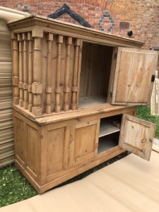Mid 19th Century Pine Pillared Housekeepers Cupboard Stunning Turned Pillars All Around The Top Cupboard Centred Mirrored Door With Storage Hooks For Hanging Housekeeping Items Two Door Cupboard At The Bottom With Shelving And Storage Space Stunning Honey Pine A Lovely Golden Colour Stands On Turned Bun Feet Heavy Item Top Lifts Off Exceptional Antique Piece Dated 1875 Made In Cheshire By A Local Cabinet Maker Was Purchase From A Manor House Would Be Perfect On A Manor Or Farm House Stunning Conversation Piece Weight Approx 90kg Dimensions In Inches Height 72.5” Width 69” Depth 27”