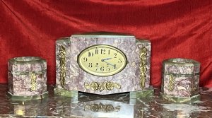 French Art Deco Marble Mantle Clock With Matching Garnitures Circa - 1920 Composition - Solid Marble/ Metal Filigree Listing Description Exceptional Period Art Deco Mantle Clock Garniture. Timepiece Comprised Of Rectangular Central Pediment, With Surrounding Canted Corner Pediments Set Upon Ornate Green Marble Feet And Matching Top Housing. All Embellished With Ornate Floral Plaques. Oval Brass Numeral Dial Run By 8 Day Mechanical Movement Wound On Clock Face. Set Complete With Pair Of Matching Octagonal Candles Garnitures. Dimensions In Inches Clock Height 8 3/4" X Width 13.5" X Depth 5 1/4" Garnitures Height 5.5" X Width 5 1/4" X Depth 4 1/4" For Any Further Information Please Call The Curator On 07707 488 566 Thank-you