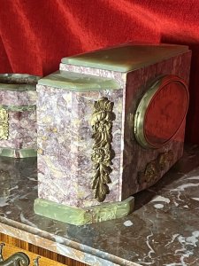 French Art Deco Marble Mantle Clock With Matching Garnitures Circa - 1920 Composition - Solid Marble/ Metal Filigree Listing Description Exceptional Period Art Deco Mantle Clock Garniture. Timepiece Comprised Of Rectangular Central Pediment, With Surrounding Canted Corner Pediments Set Upon Ornate Green Marble Feet And Matching Top Housing. All Embellished With Ornate Floral Plaques. Oval Brass Numeral Dial Run By 8 Day Mechanical Movement Wound On Clock Face. Set Complete With Pair Of Matching Octagonal Candles Garnitures. Dimensions In Inches Clock Height 8 3/4" X Width 13.5" X Depth 5 1/4" Garnitures Height 5.5" X Width 5 1/4" X Depth 4 1/4" For Any Further Information Please Call The Curator On 07707 488 566 Thank-you