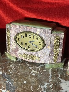 French Art Deco Marble Mantle Clock With Matching Garnitures Circa - 1920 Composition - Solid Marble/ Metal Filigree Listing Description Exceptional Period Art Deco Mantle Clock Garniture. Timepiece Comprised Of Rectangular Central Pediment, With Surrounding Canted Corner Pediments Set Upon Ornate Green Marble Feet And Matching Top Housing. All Embellished With Ornate Floral Plaques. Oval Brass Numeral Dial Run By 8 Day Mechanical Movement Wound On Clock Face. Set Complete With Pair Of Matching Octagonal Candles Garnitures. Dimensions In Inches Clock Height 8 3/4" X Width 13.5" X Depth 5 1/4" Garnitures Height 5.5" X Width 5 1/4" X Depth 4 1/4" For Any Further Information Please Call The Curator On 07707 488 566 Thank-you