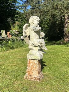 Cherub ‘The Horn Blower’ Garden Showpiece Circa - 1890 Composition- Reconstituted Stone Cherub With Iron Base Listing Description Classical Large Winged Putti Garden Statue In Fine Detail, Posed Blowing Musical Horn And Sat With Loin Cloth Upon Fluted Base. Set Upon Cast Iron Plinth. Stunning Feature For Period Garden Setting. Provenance Purchased From Country Estate In Kent. Dimensions In Cm Total Height 108 cm Statute Width 33cm Base 37cm X 27cm Depth