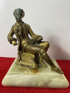 Composition - Bronze Ormolu & Bronze. Set Upon Rectangular Onyx Base.  Showing Signs Of Wear To Face Due To Age. Sits Wearing Gown With 3/4 Lace Sleeves With Oversized Pin Striped Pleated Skirt. Holds Large Bowl In Left Hand With Right Articulating Arm.
